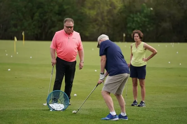 Instructor coaching golfers on the range