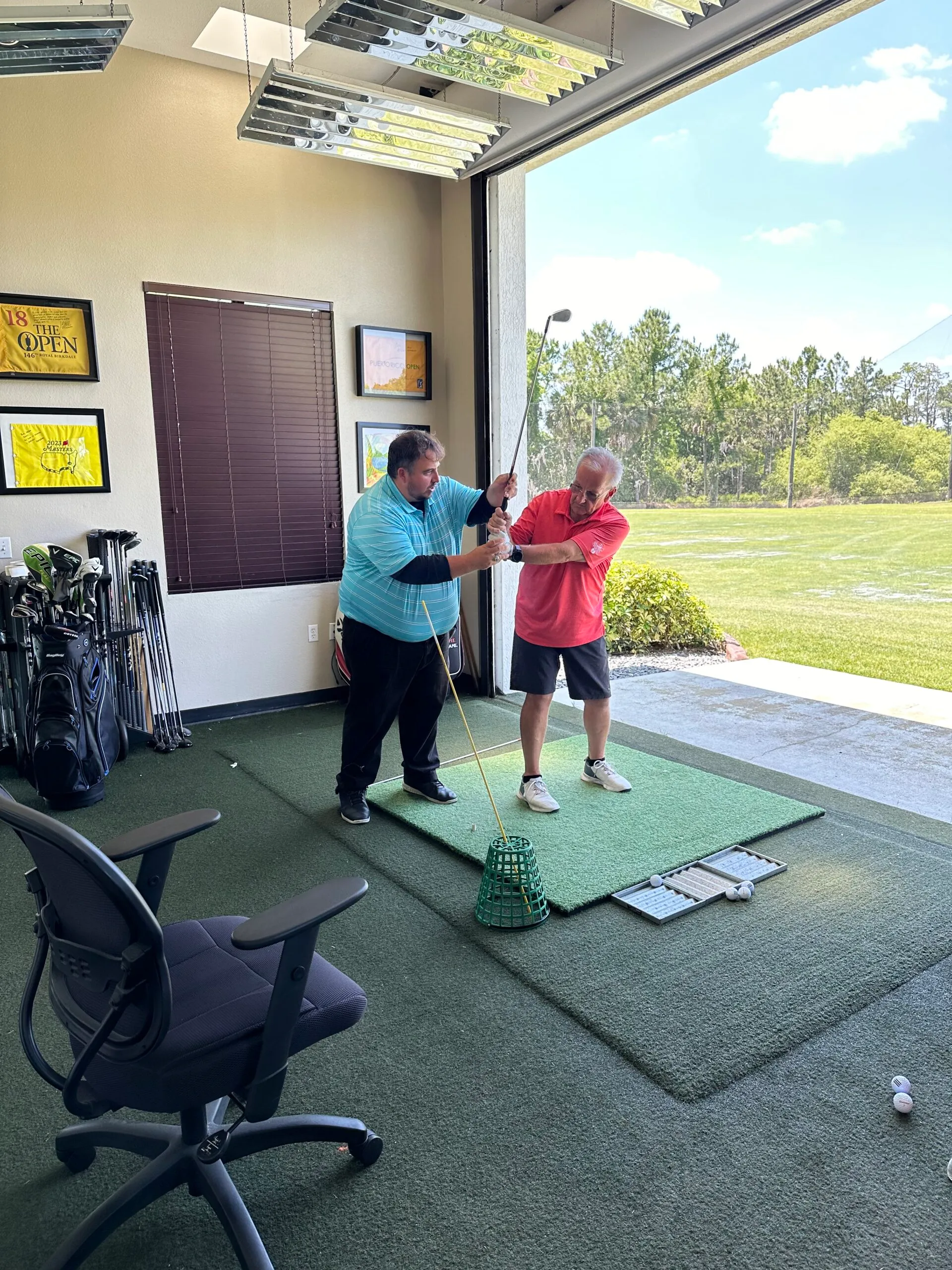 Instructor working with a student in the hitting bay