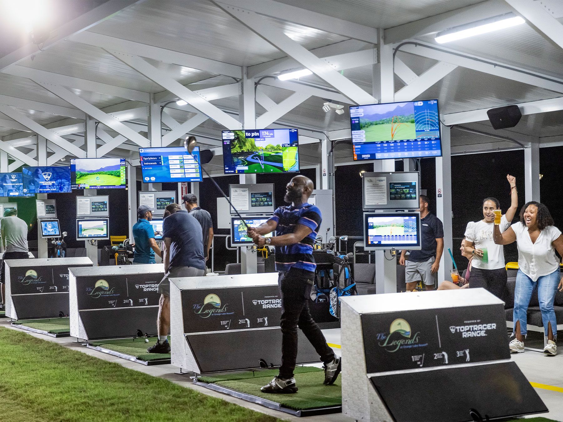 Friends playing in the lighted Toptracer bays at night